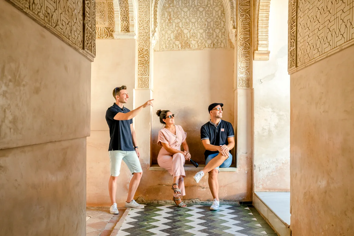 Eine Gruppe von drei Menschen in der Alhambra in Granada.